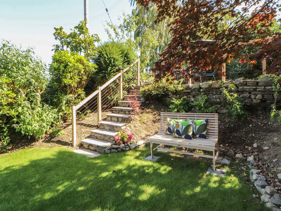 A garden with stairs and a bench at Haws Bank Cottage in Coniston