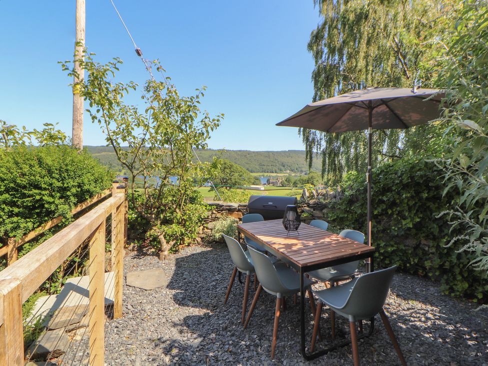A garden with a table and chairs at Haws Bank Cottage in Coniston