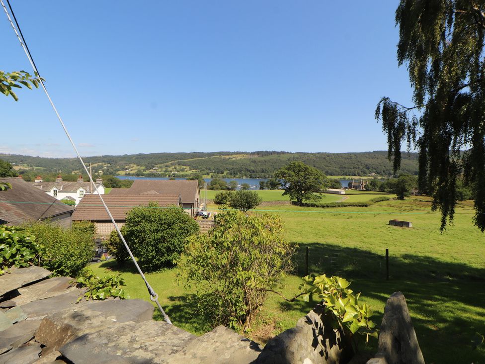 A view of houses and a lake from a garden at Haws Bank Cottage in Coniston