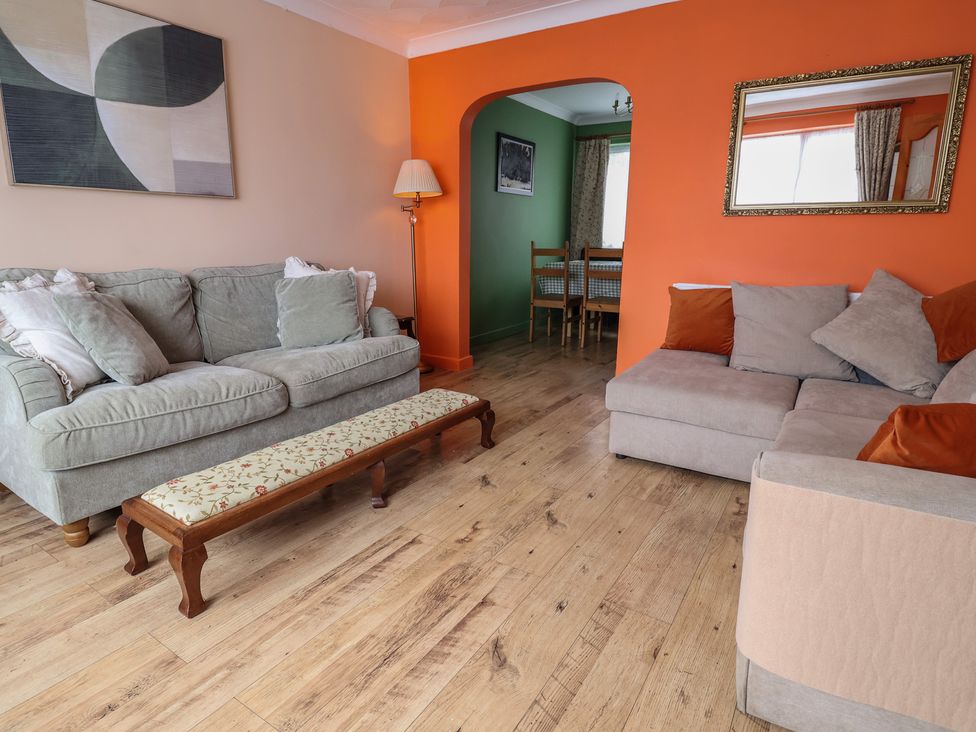 A living room with a sofa and bench at Hafan Deg in Holywell