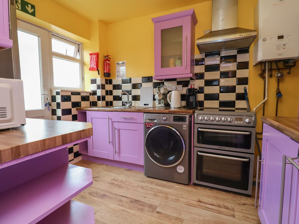 A kitchen with washing machine and oven at Hafan Deg in Holywell