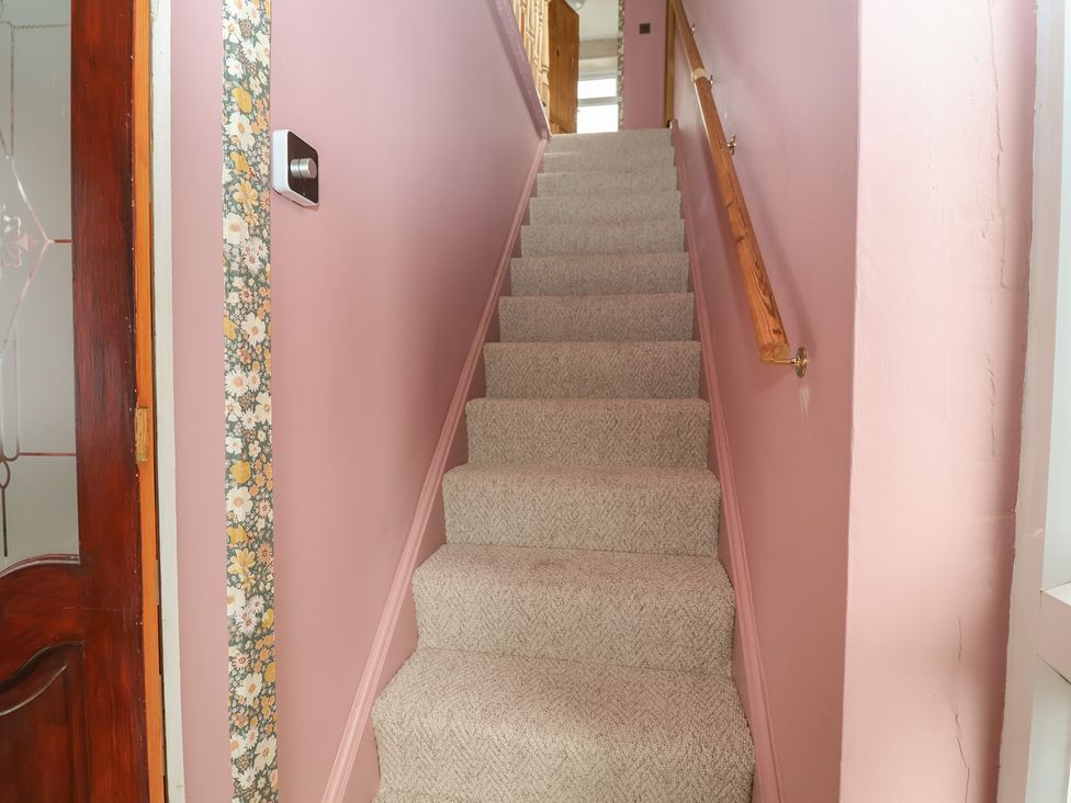 A staircase with carpet and a handrail at Hafan Deg in Holywell