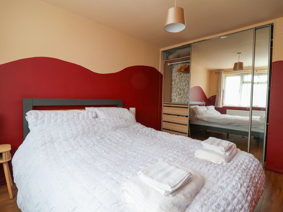A bedroom with a double bed and mirror wardrobe at Hafan Deg in Holywell