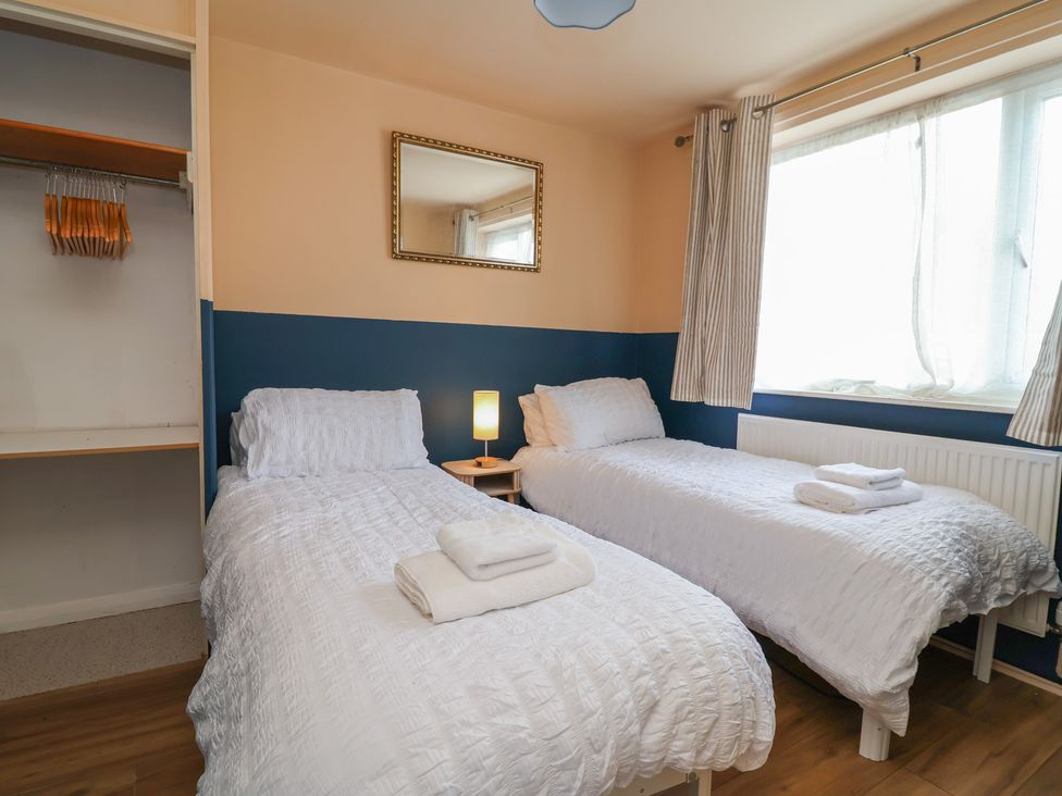 A bedroom with twin beds and a mirror at Hafan Deg in Holywell