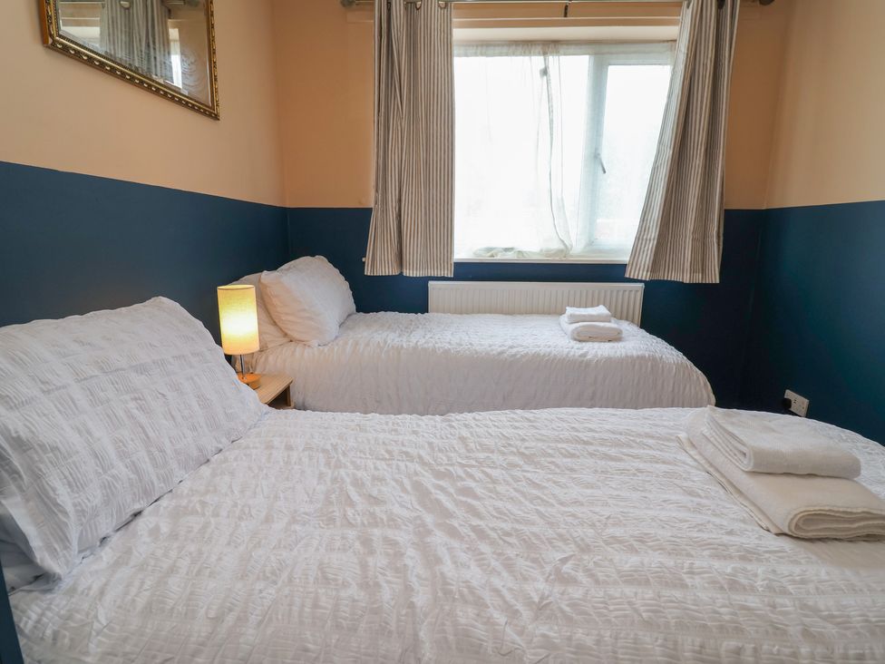 A bedroom with two beds and a window at Hafan Deg in Holywell