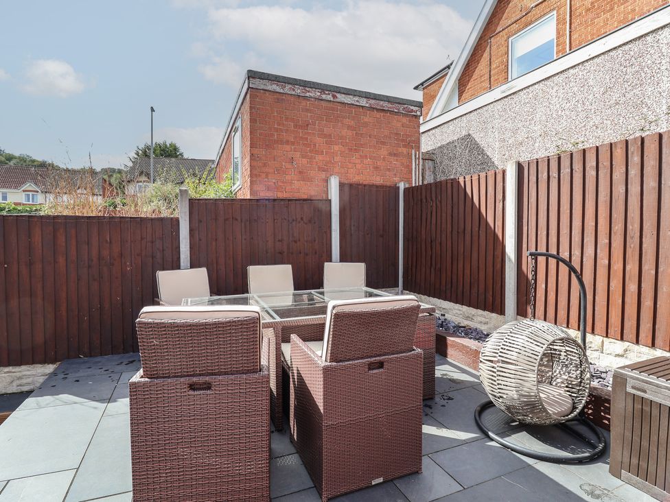 A garden with outdoor furniture and a hanging chair at Hafan Deg in Holywell