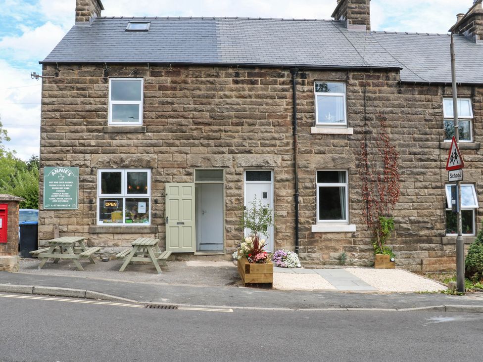 A building with a sign and outdoor seating at 2 Bentley Bridge Cottages Matlock