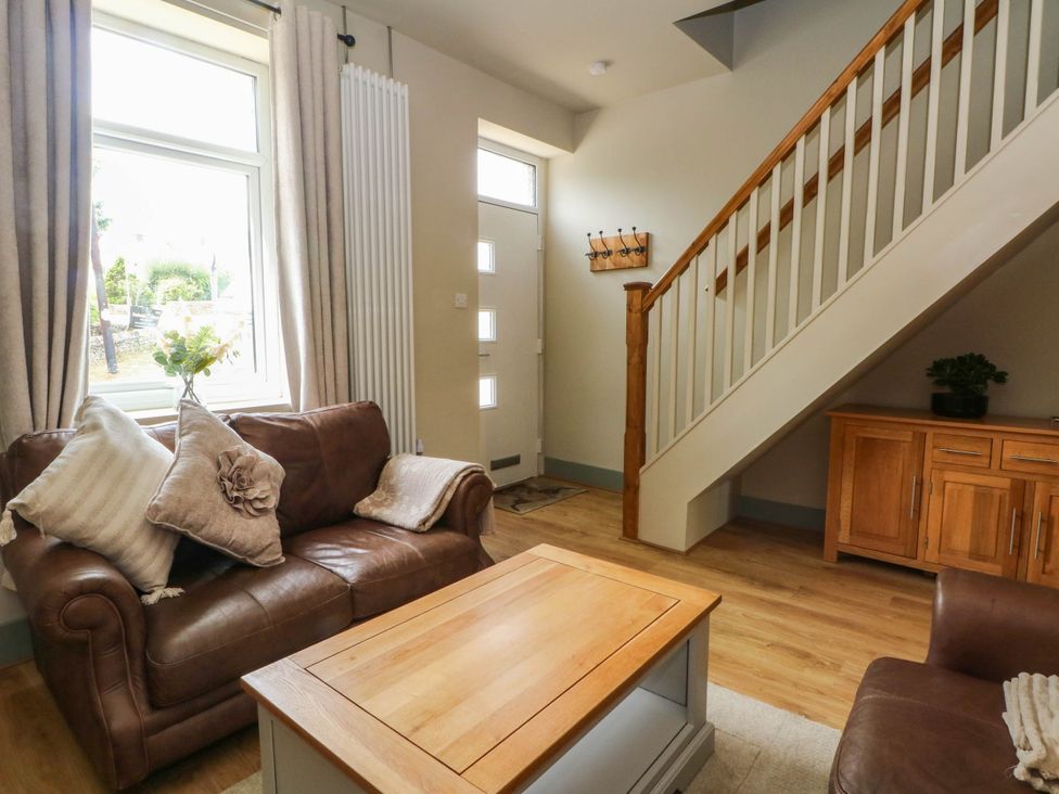 A living room with a sofa and coffee table at 2 Bentley Bridge Cottages, Matlock
