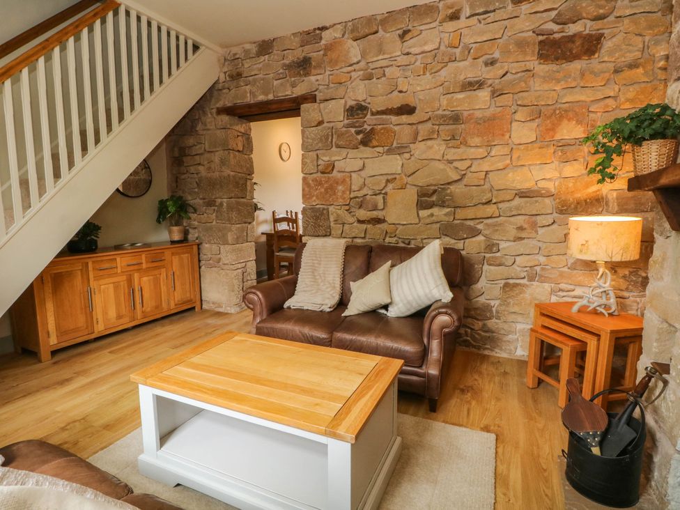 A living room with a sofa and coffee table at 2 Bentley Bridge Cottages in Matlock