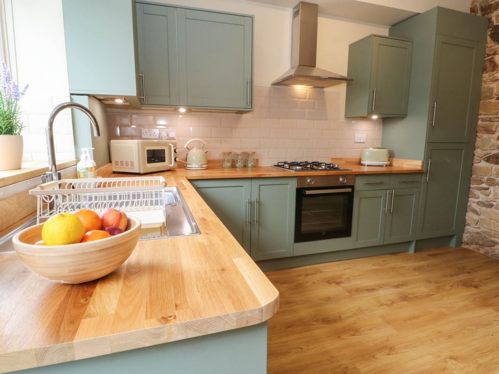 A kitchen with a countertop, sink, and appliances at 2 Bentley Bridge Cottages Matlock