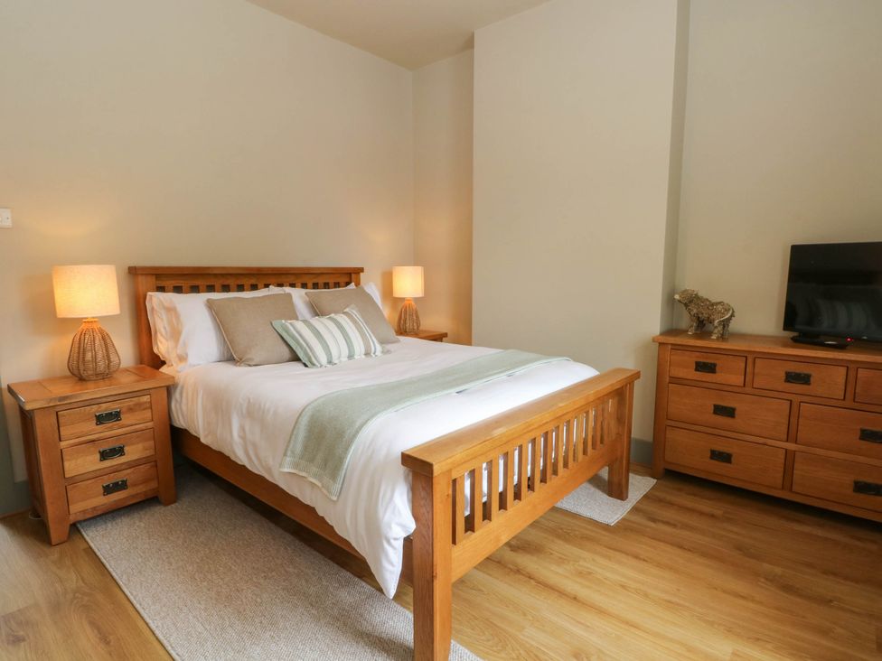 A bedroom with a bed and two nightstands at 2 Bentley Bridge Cottages Matlock