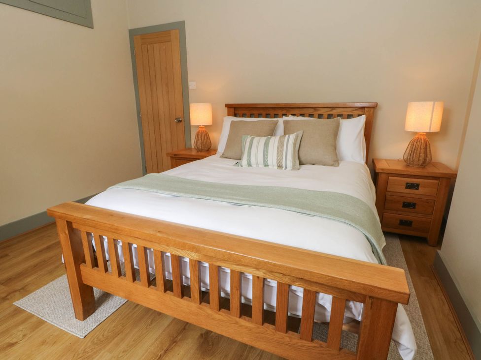 A bedroom with a bed and nightstands at 2 Bentley Bridge Cottages in Matlock