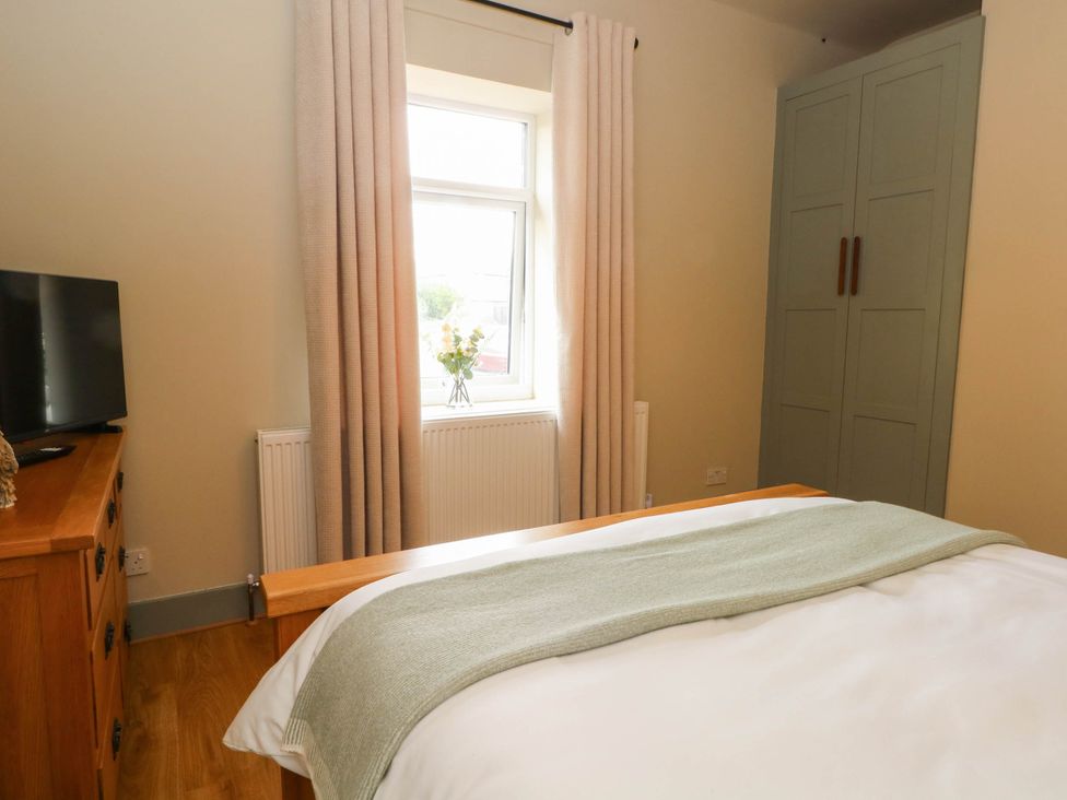 A bedroom with a bed and wardrobe at 2 Bentley Bridge Cottages Matlock