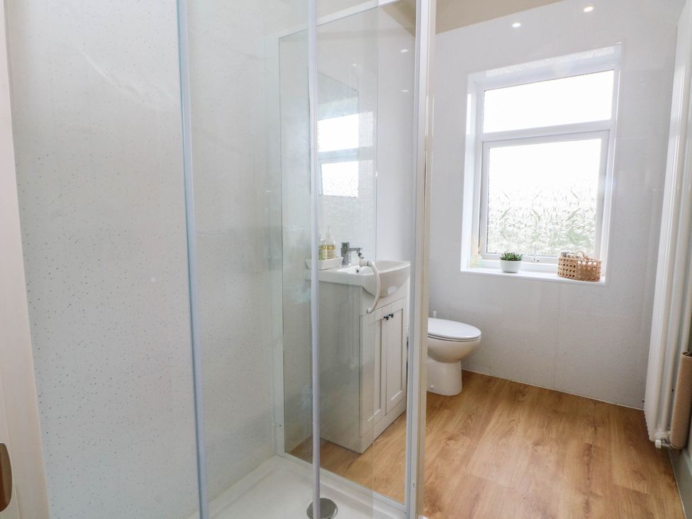 A bathroom with a shower, sink, and toilet at 2 Bentley Bridge Cottages in Matlock