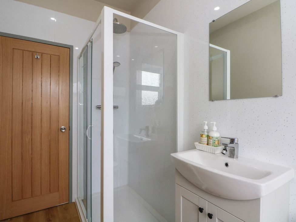 A bathroom with a shower and sink at 2 Bentley Bridge Cottages in Matlock