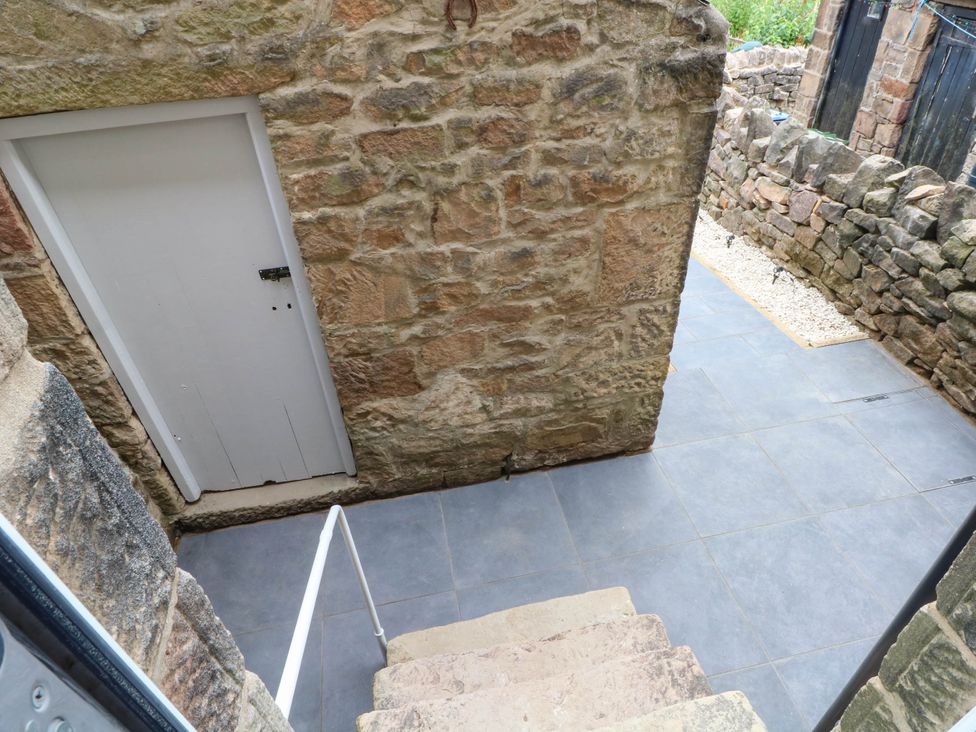 An outdoor area with stairs leading down to a door at 2 Bentley Bridge Cottages Matlock