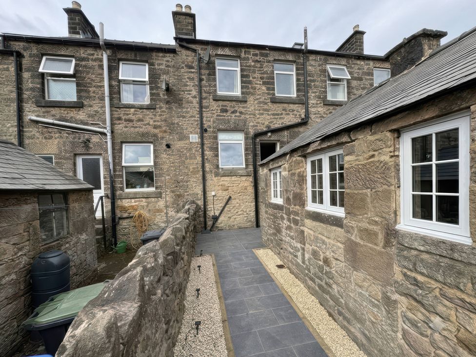 An outdoor area with stone walls and a pathway at 2 Bentley Bridge Cottages, Matlock