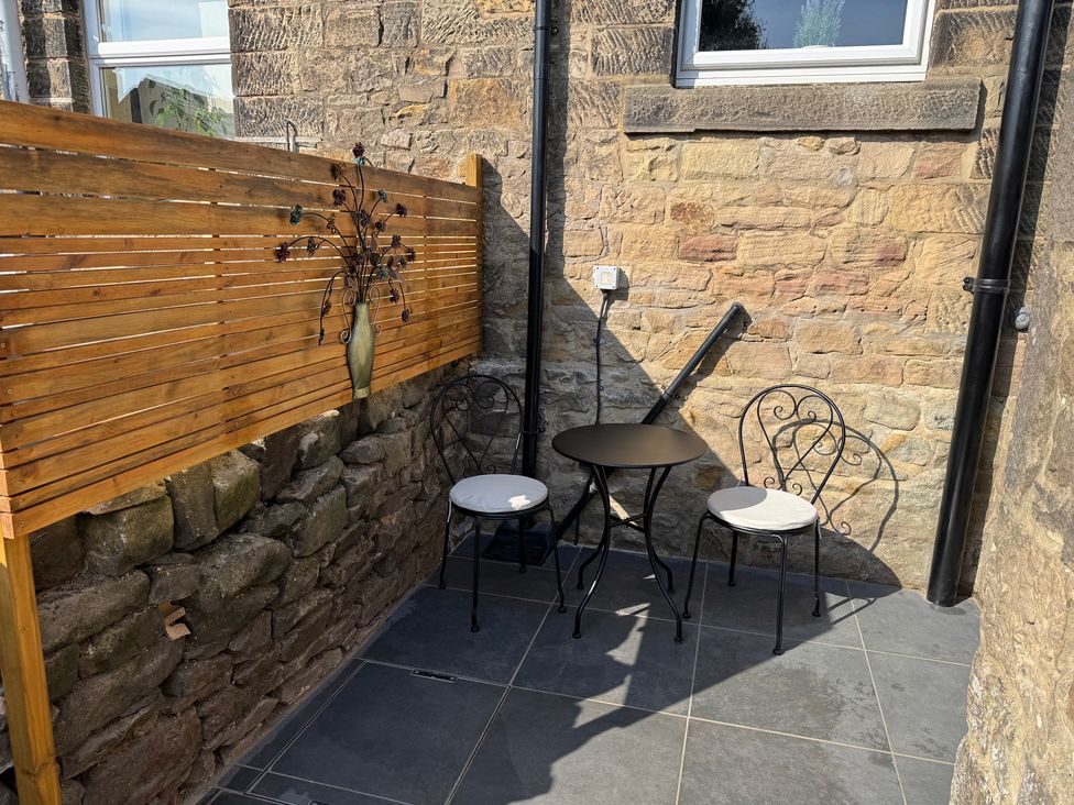 A seating area with a table and chairs at 2 Bentley Bridge Cottages in Matlock