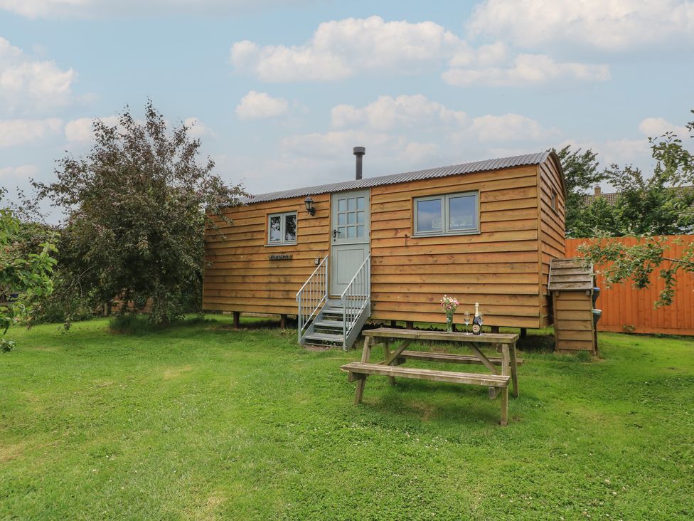 A wooden house with steps and a picnic table at Damsons in Williton