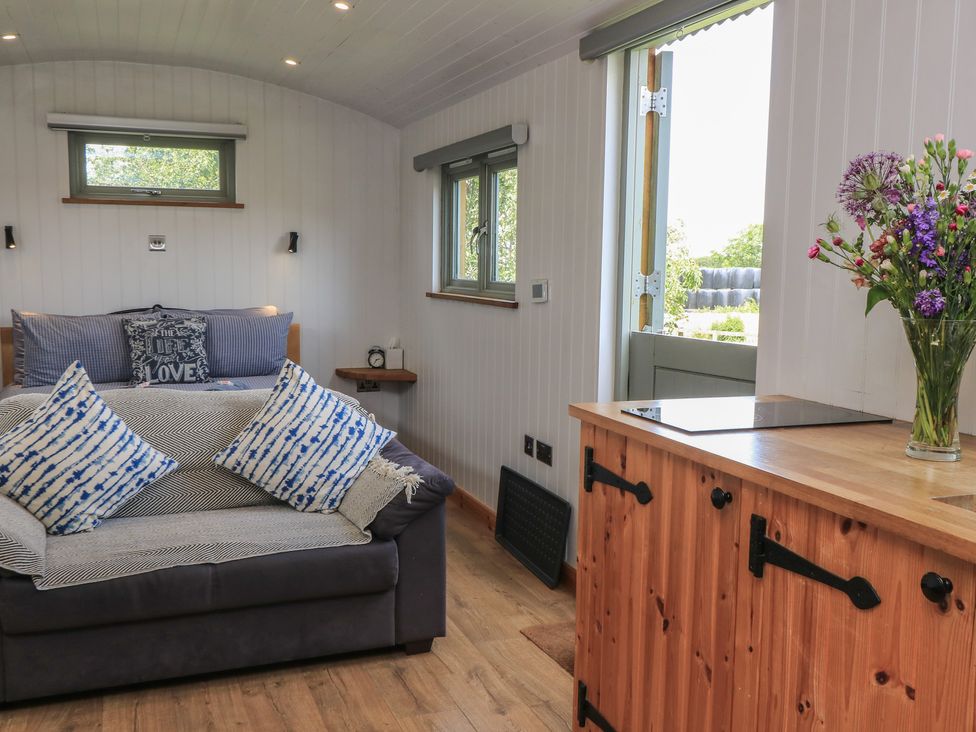 A living room with a sofa bed and a table at Damsons in Williton
