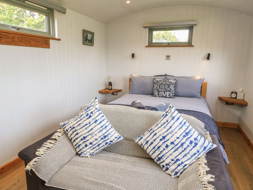 A bedroom with a bed and decorative pillows at Damsons in Williton