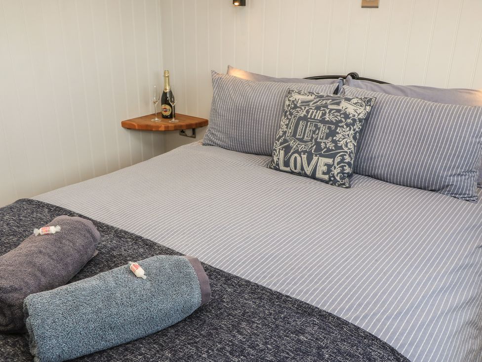 A bedroom with a bed and towels at Damsons in Williton