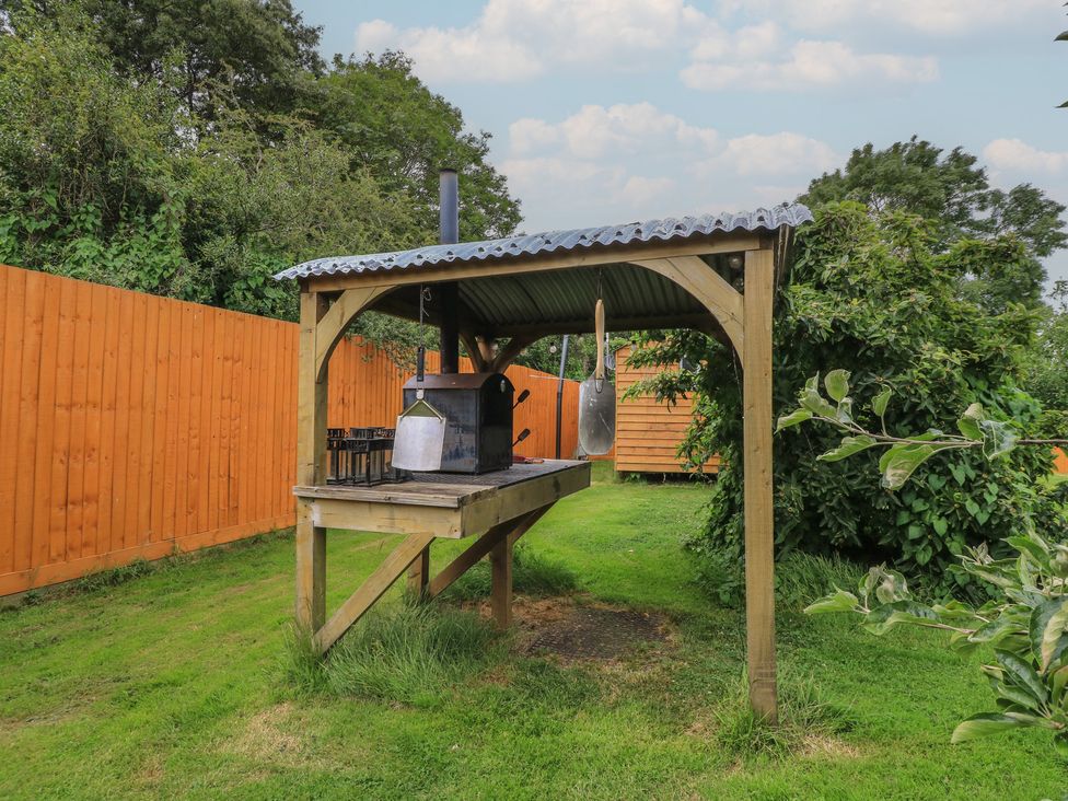 A barbecue setup with a grill under a shelter in the garden at Damsons Williton