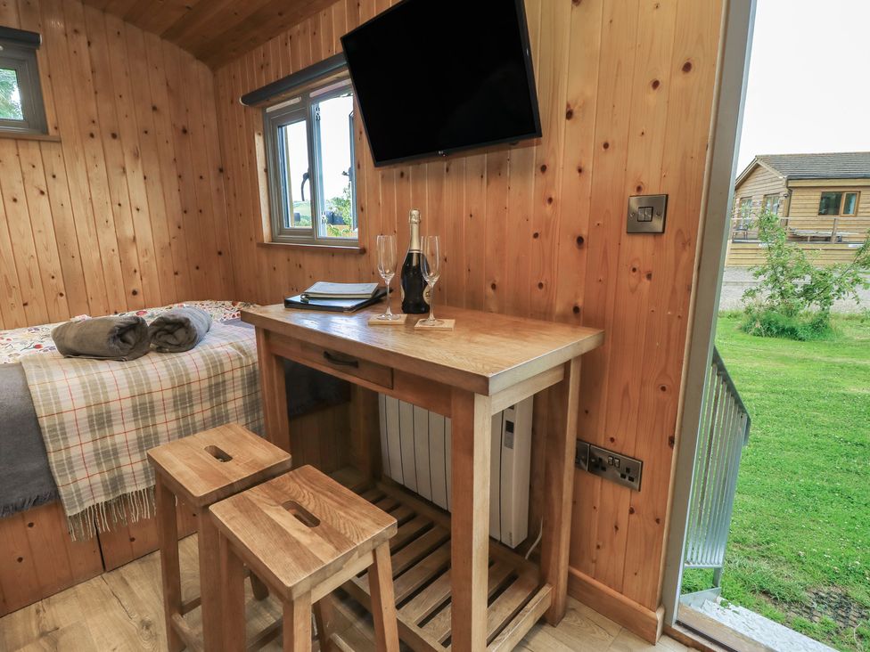 A bedroom with a table and stools at Pippins in Taunton