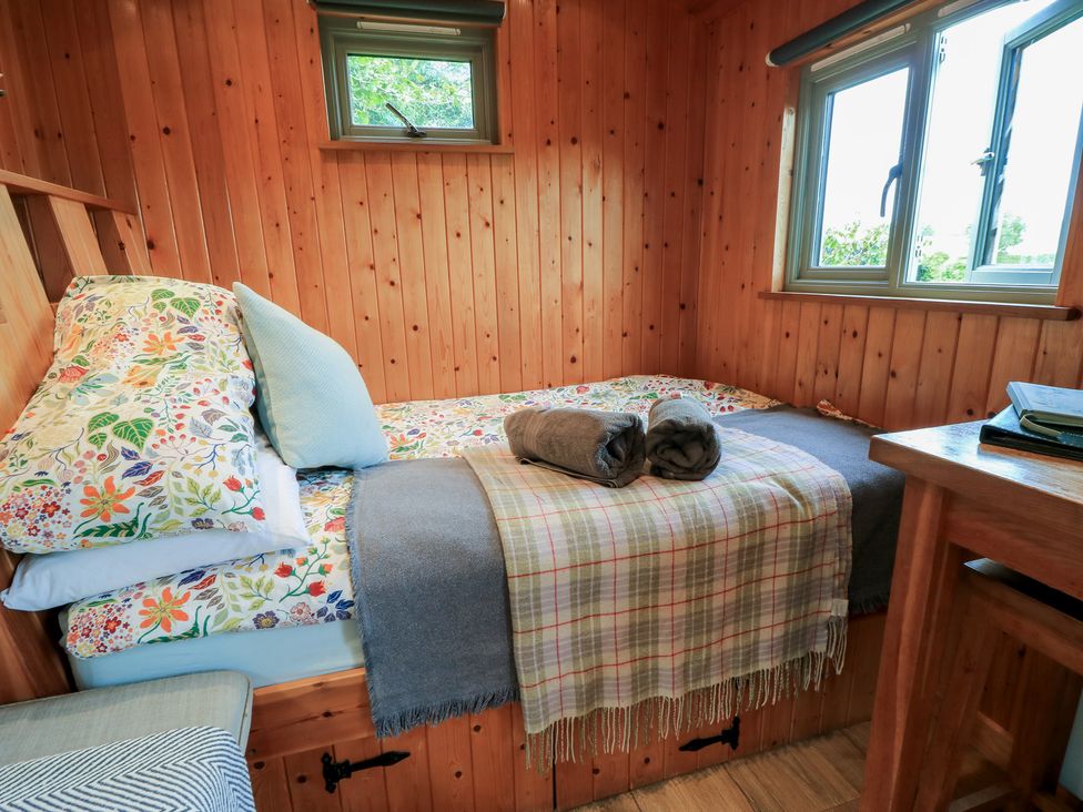 A bedroom with a bed and a table at Pippins in Taunton