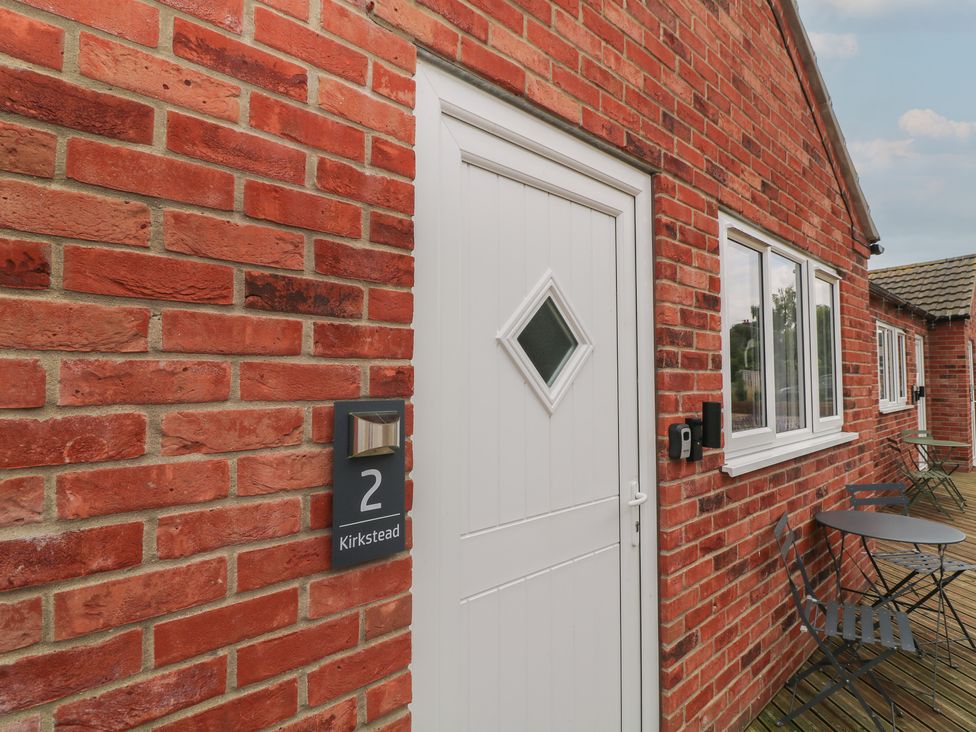 An exterior view of a house with a white door and brick wall at Kirkstead in Billinghay, Lincolnshire