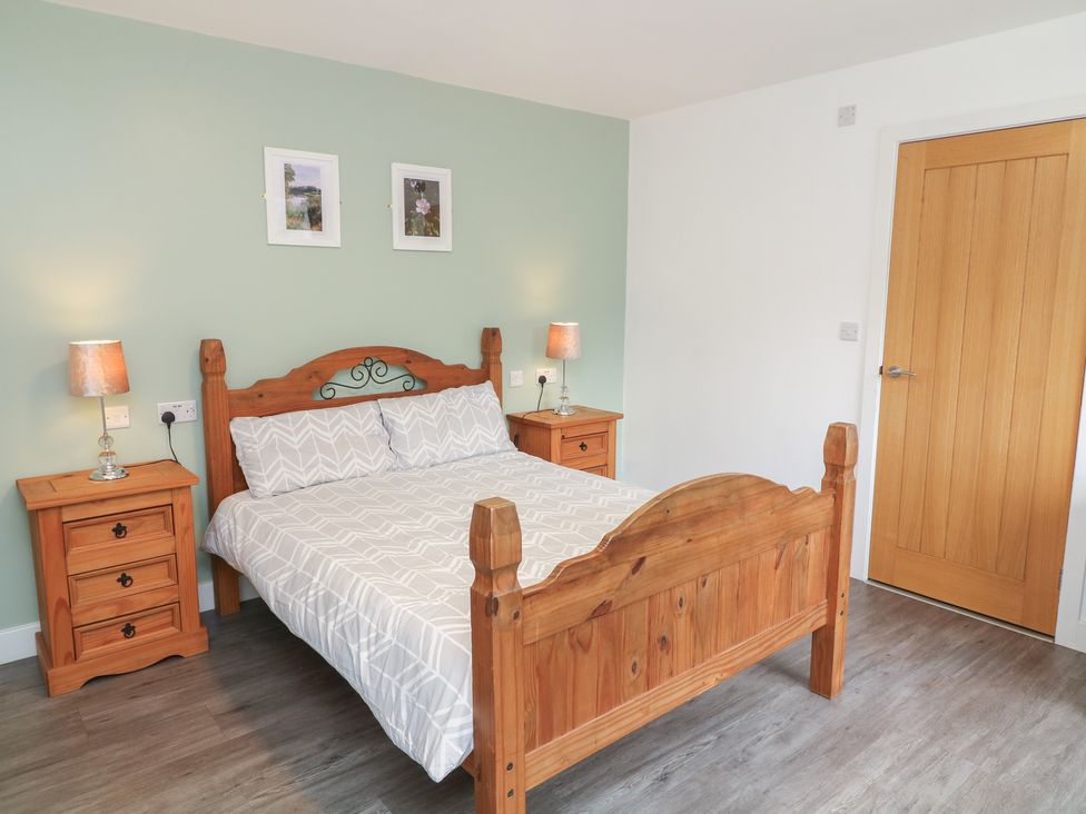 A bedroom with a wooden bed and bedside tables at Kirkstead in Billinghay, Lincolnshire