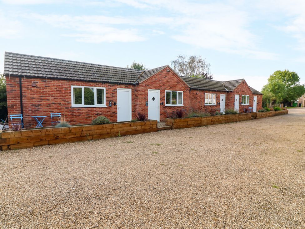 An outdoor view of brick buildings with windows and doors at Walcott Lodges - Kirkstead in Billinghay, Lincolnshire