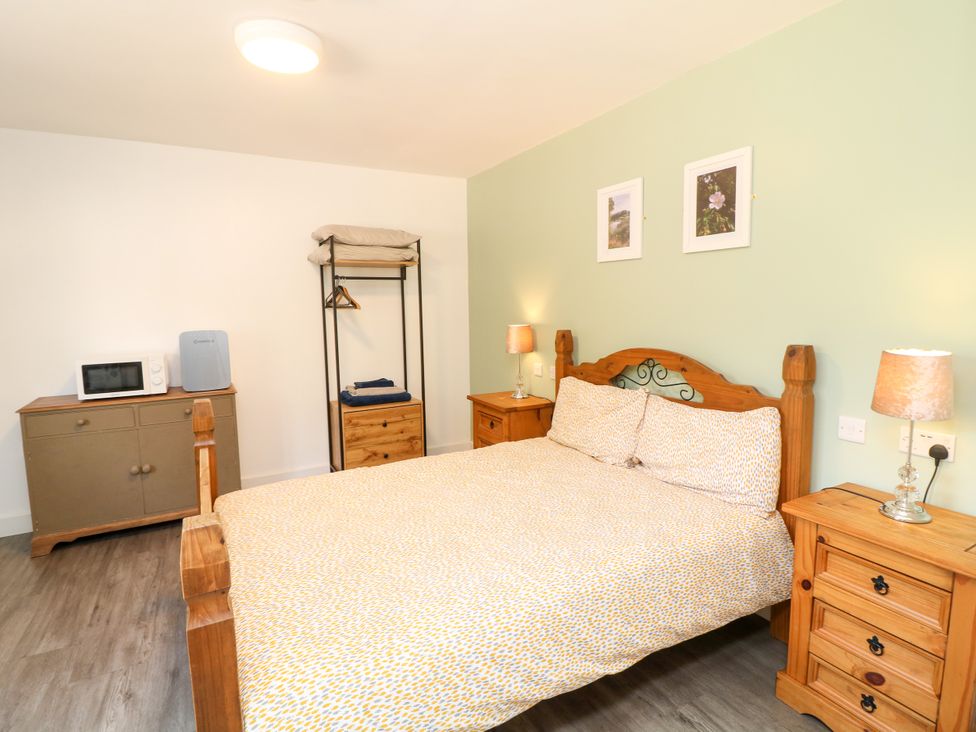 A bedroom with a bed and nightstand at Walcott Lodges - Kirkstead Billinghay, Lincolnshire