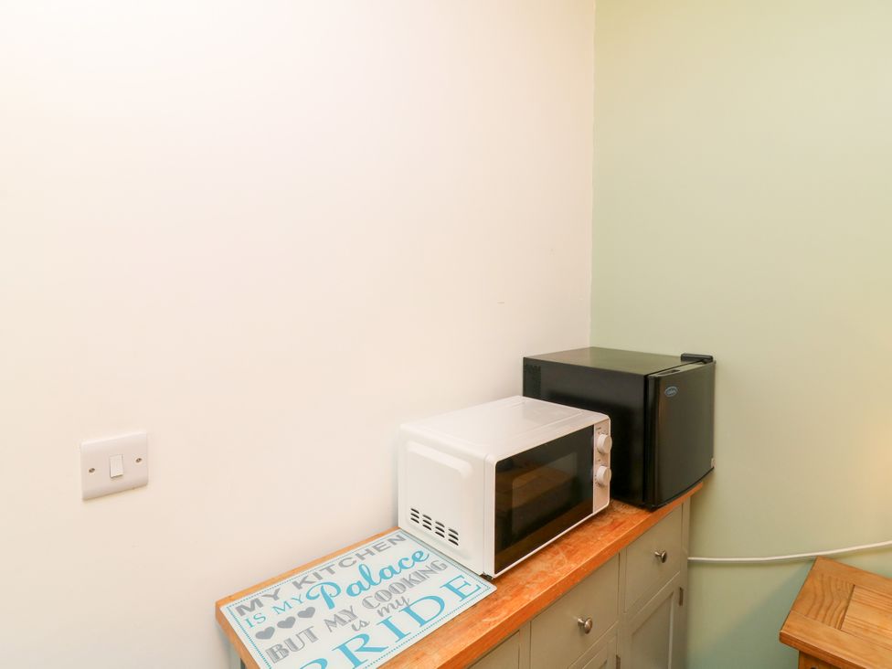 A countertop with a microwave and mini fridge at Walcott Lodges - Barlings, Billinghay, Lincolnshire