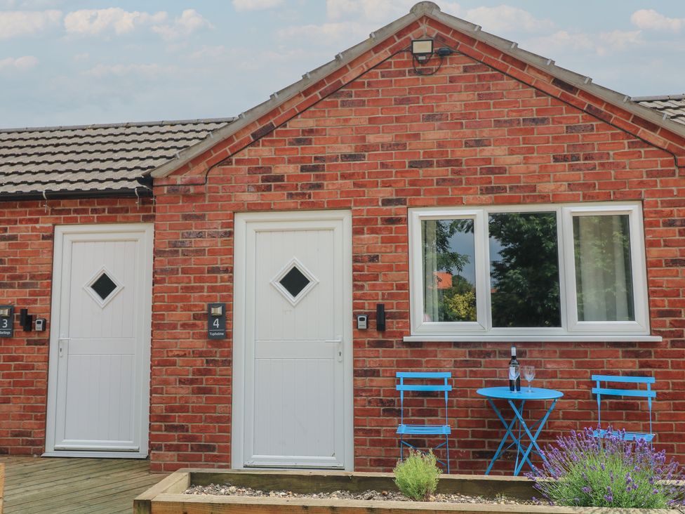 An outdoor area with two doors, a table and chairs at Tupholme Billinghay, Lincolnshire