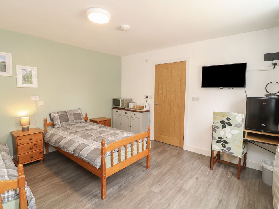 A bedroom with two beds and a kitchenette at Tupholme in Billinghay, Lincolnshire