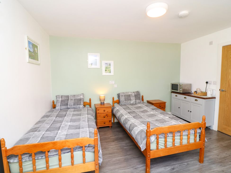A bedroom with two beds and a microwave at Walcott Lodges - Tupholme, Billinghay, Lincolnshire