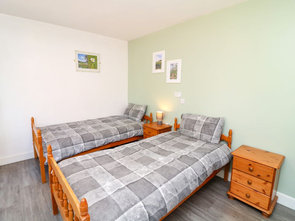 A bedroom with two single beds and wooden furniture at Walcott Lodges - Tupholme, Billinghay, Lincolnshire