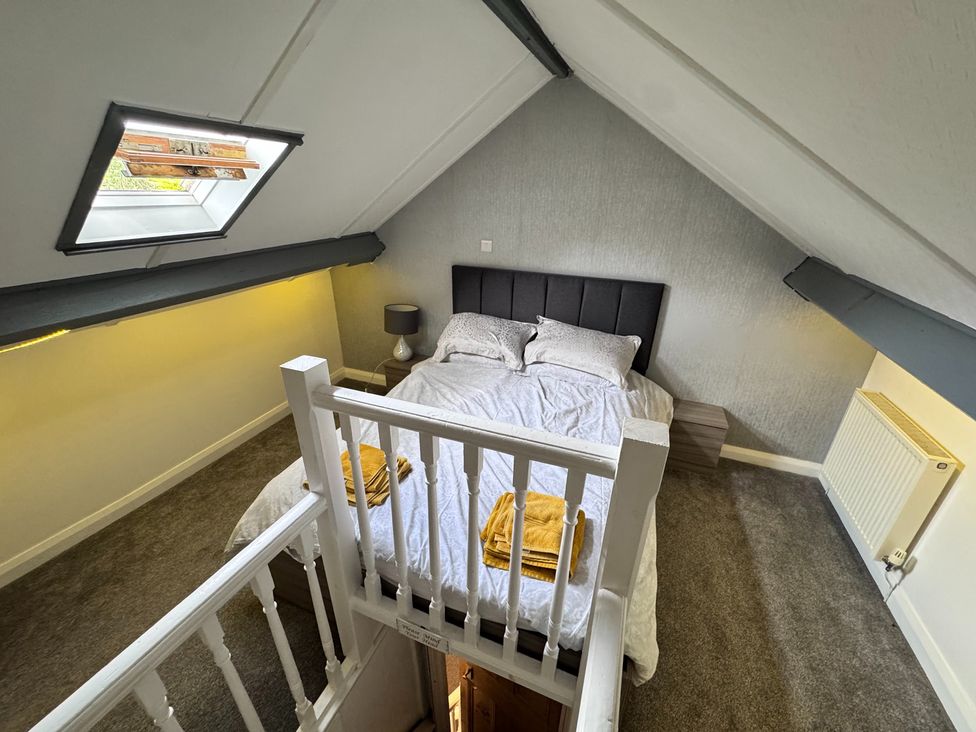 A bedroom with a bed and side table at Conway Mart Cottage in Conwy