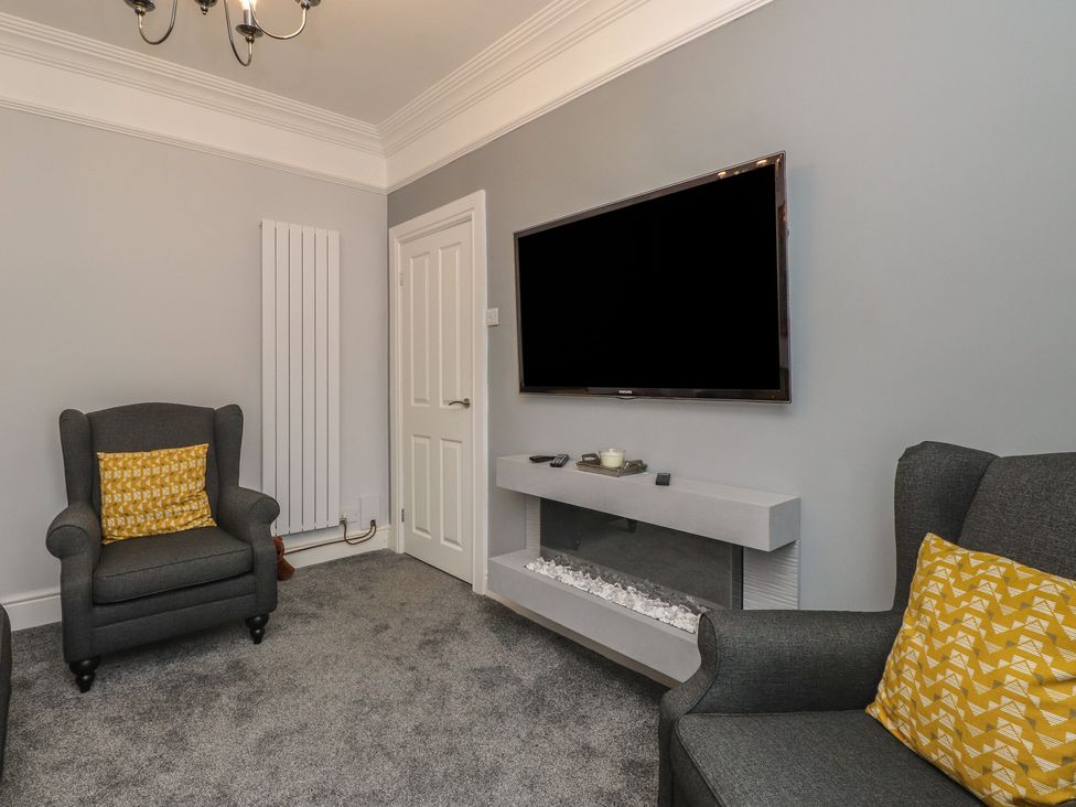A living room with a television mounted on the wall at Conway Mart Cottage in Conwy