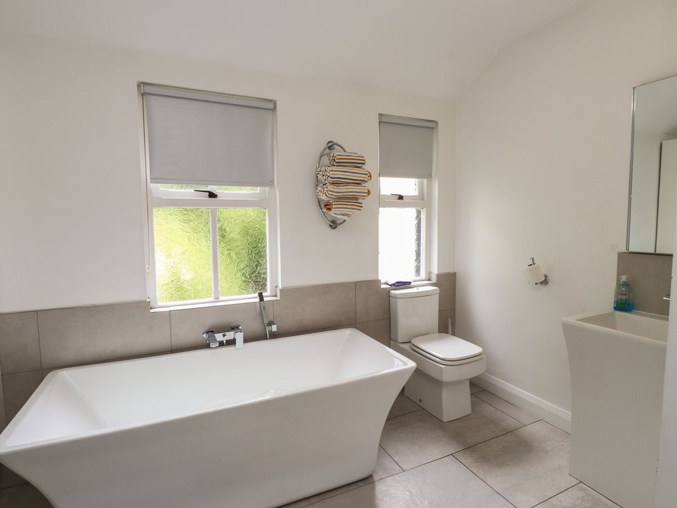 A bathroom with a bathtub and a toilet at Conway Mart Cottage in Conwy