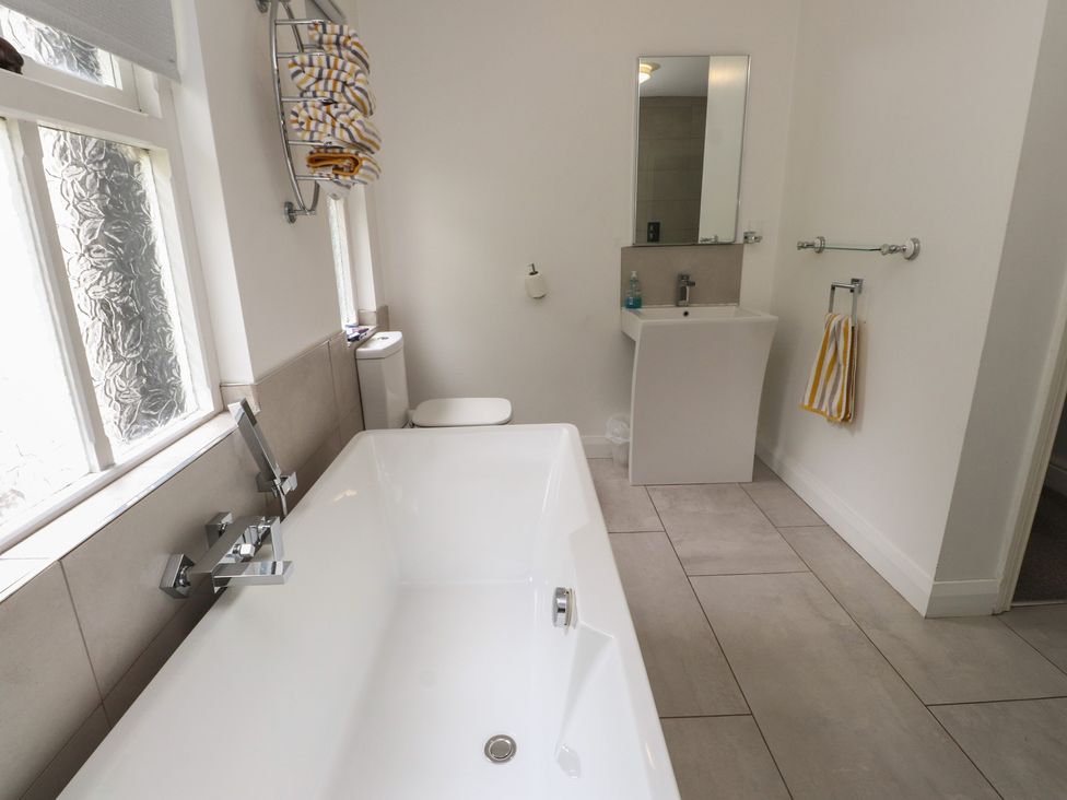A bathroom with a bathtub, sink, and toilet at Conway Mart Cottage in Conwy