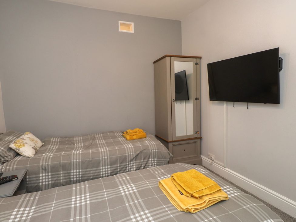 A bedroom with two beds and a television at Conway Mart Cottage in Conwy