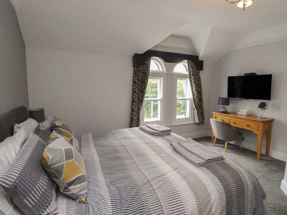 A bedroom with a bed and desk at Conway Mart Cottage in Conwy
