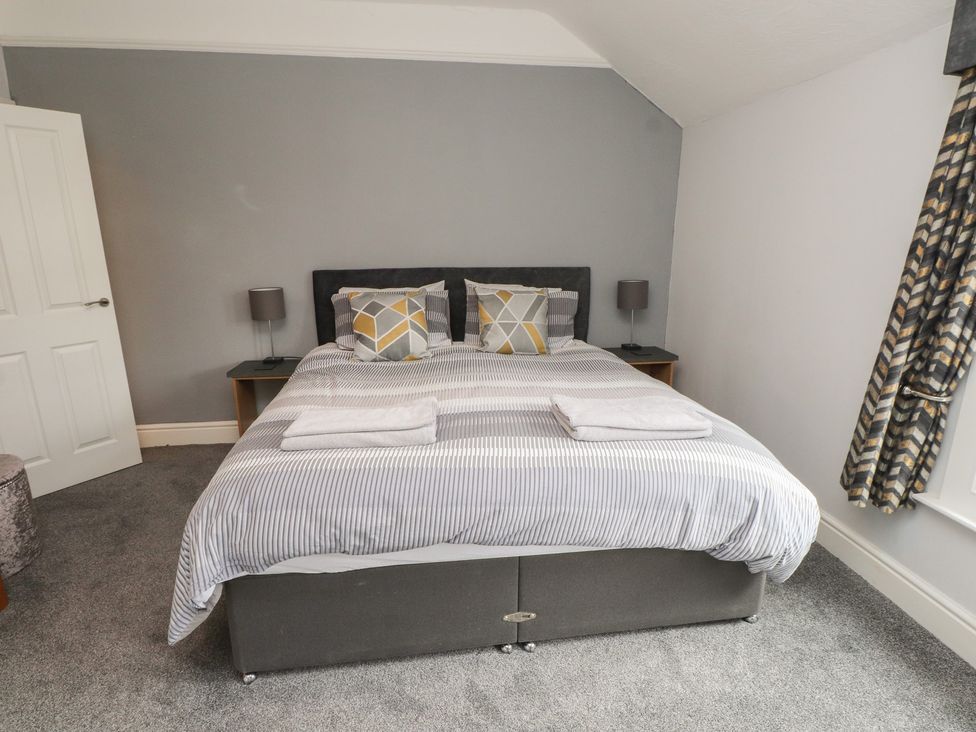 A bedroom with a bed and lamps at Conway Mart Cottage in Conwy
