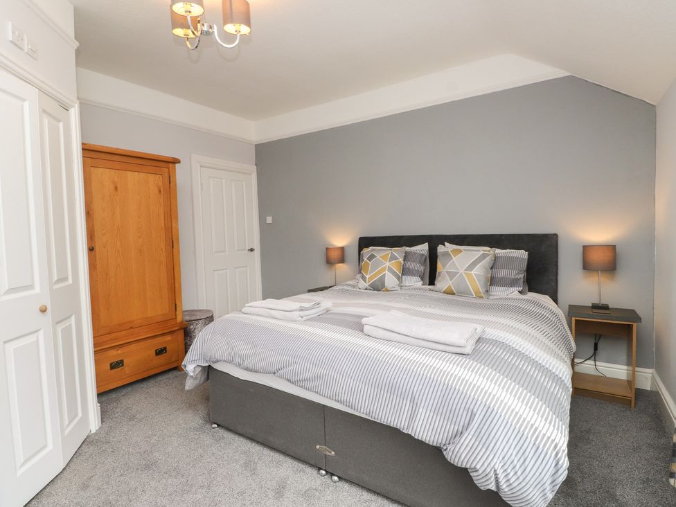 A bedroom with a bed and wardrobe at Conway Mart Cottage in Conwy