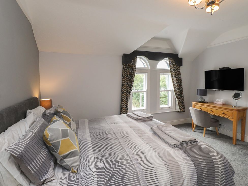 A bedroom with a bed and a desk at Conway Mart Cottage in Conwy
