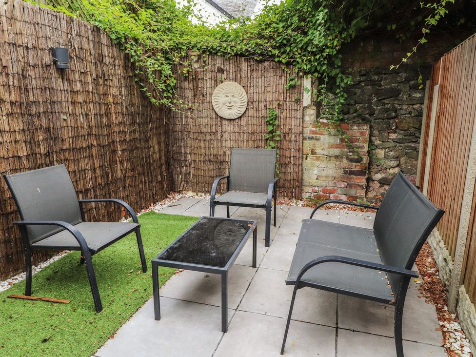 A garden featuring chairs and a table at Conway Mart Cottage in Conwy