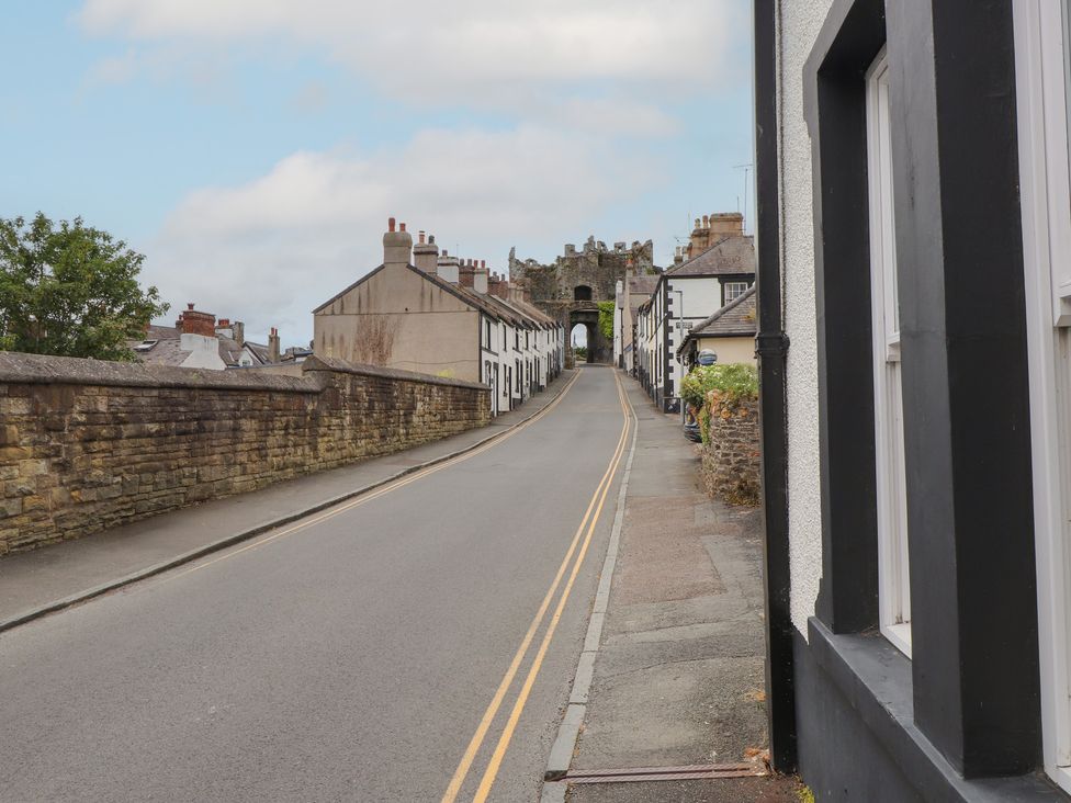 A street with buildings and a gate in the distance at Conway Mart Cottage in Conwy