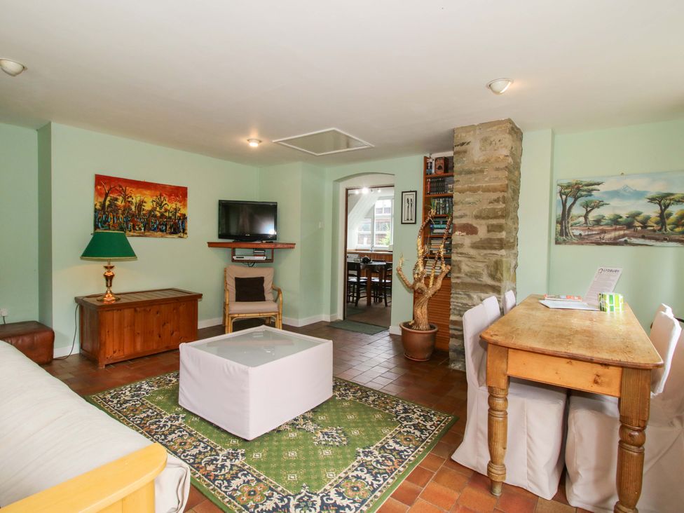 A living room with a sofa and dining table at Kwerky Cottage